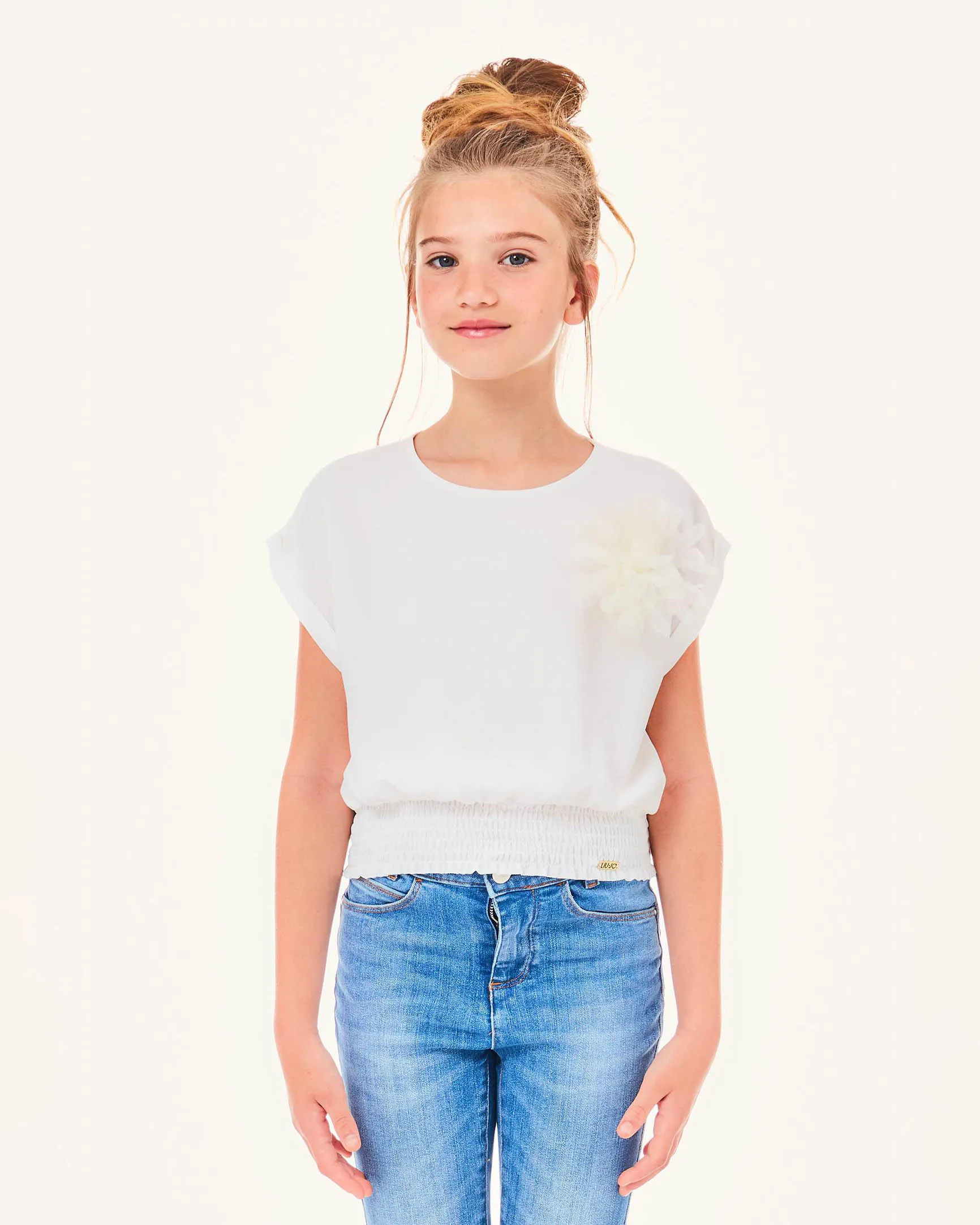 Blusa bianca in crêpe con punto smock in vita e applicazione floreale 10-16 anni